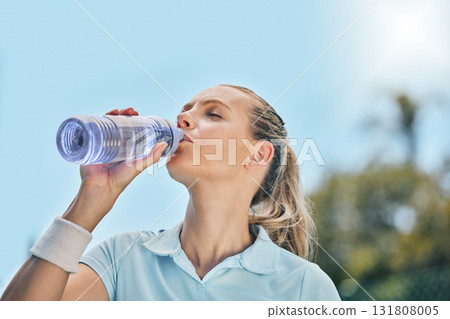 Woman, tennis player and drinking water for hydration after workout, exercise or intense training in nature. Sporty female with bottle for refreshing drink to stay hydrated during sports exercising 131808005