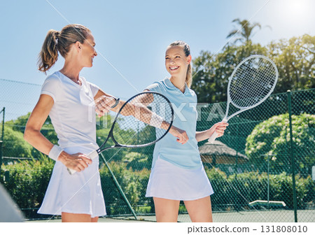 Woman, tennis court and together for smile, athlete and support with elbow for motivation at training. Women, coaching and respect with sport, goals or happy for workout, exercise or excited for game Woman, tennis court and together for smile, athlete and support with elbow for motivation at training. Women, coaching and respect with sport, goals or happy for workout, exercise or excited for game 131808010