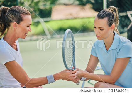 Women hands together, tennis racket and coach with athlete, support or helping hand at training. Woman, coaching and learning for sports, teaching or advice by blurred background outdoor for strategy 131808024