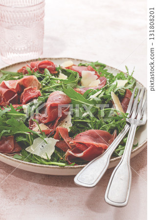 Fresh arugula salad with prosciutto and grated parmesan cheese, on a plate, homemade, no people, 131808201