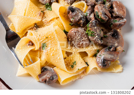 Delicious pappardelle pasta with mushrooms and cream served on a white plate 131808202