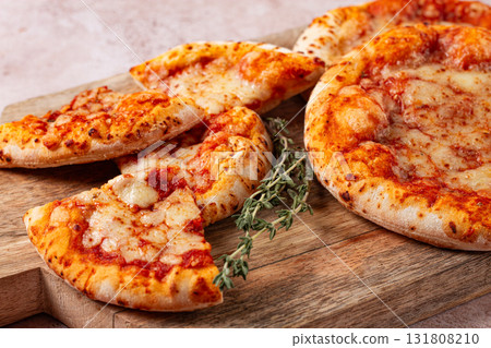 Four pizzetta Margaritas, on a cutting board, on a light gray surface, top view, Four pizzetta Margaritas, on a cutting board, on a light gray surface, top view, 131808210