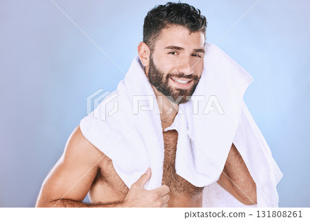Man after shower with hygiene, towel and beauty in portrait, smile, face and grooming in studio. Skincare, cosmetics and cleaning body with healthy skin, mockup and cosmetic care on blue background 131808261