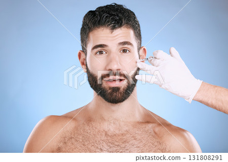 Needle, man and portrait for skincare, collagen and beauty process in studio. Cosmetics, surprise face and injection for plastic surgery of botox, facial change and aesthetic prp on blue background Needle, man and portrait for skincare, collagen and beauty process in studio. Cosmetics, surprise face and injection for plastic surgery of botox, facial change and aesthetic prp on blue background 131808291