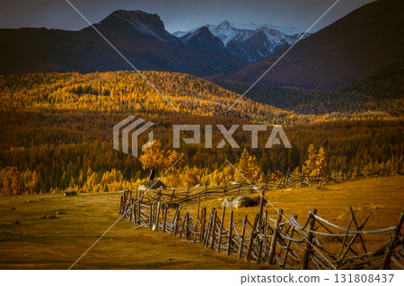 Rustic fence in autumn valley with mountains in the background 131808437