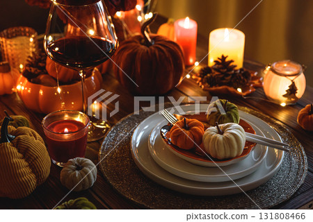Autumnal table setting with decorative pumpkins, candles and string lights. Autumnal table setting with decorative pumpkins, candles and string lights. 131808466