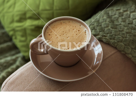 Cup of Hot Coffee Stay on Arm of Cozy Couch by Blanket Cup of Hot Coffee Stay on Arm of Cozy Couch by Blanket 131808470