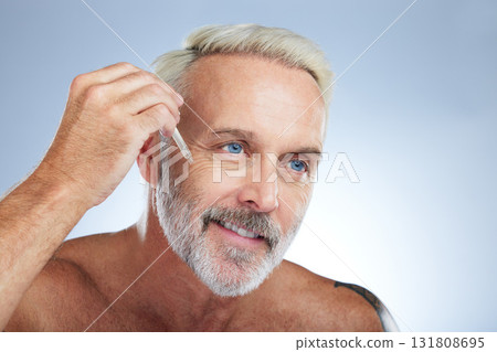 Old man, smile and facial oil for skincare, beauty and grooming, apply serum on face against studio background. Dropper, anti aging cosmetic care with senior male and mockup, hygiene with dermatology 131808695