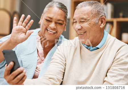 Video call, wave or old couple talking, communication or speaking in conversation in retirement at home. Partnership, elderly man or happy senior woman greeting online on phone together with smile Video call, wave or old couple talking, communication or speaking in conversation in retirement at home. Partnership, elderly man or happy senior woman greeting online on phone together with smile 131808716