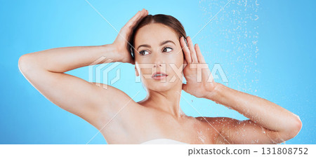Shower, water and woman washing in studio for skincare, wellness and clean body for self care. Face of female aesthetic model, splash or drops for cleaning, hygiene and cosmetics on blue background 131808752