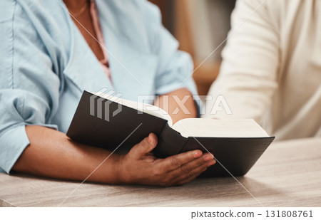 Hands, bible and books with a senior couple reading a book together in their home during retirement. Jesus, faith or belief with a man and woman praying to god in their house for spiritual bonding Hands, bible and books with a senior couple reading a book together in their home during retirement. Jesus, faith or belief with a man and woman praying to god in their house for spiritual bonding 131808761