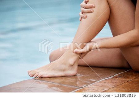 Swimmer with an ankle injury, pain or accident by the pool after water sport training or exercise. Sports, fitness and woman athlete with a leg sprain, medical emergency or torn muscle after workout. 131808819
