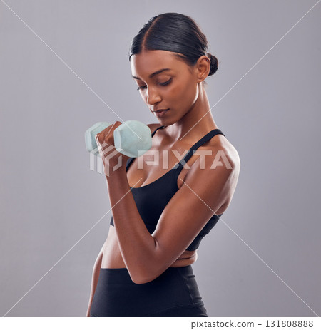 Black woman, dumbbells training and studio for muscle development, wellness and self care with focus. Gen z bodybuilder girl, exercise and strong healthy body with gym equipment by gray background 131808888