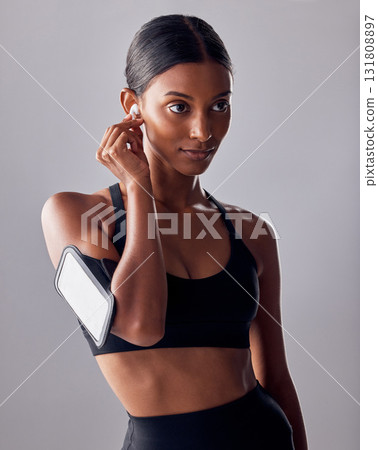 Fitness, music and woman in studio for exercise, wellness and advertising on grey background space. Workout, mockup and girl relax with podcast, audio for track for motivation while training isolated 131808897