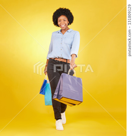 Black woman with shopping bag, portrait with fashion and retail, smile on yellow studio background. Happiness, female with discount and sale at boutique with designer brand, happy and mockup space Black woman with shopping bag, portrait with fashion and retail, smile on yellow studio background. Happiness, female with discount and sale at boutique with designer brand, happy and mockup space 131809129