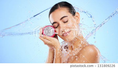 Dragon fruit, water splash or woman with beauty in studio on blue background for healthcare or vegan diet. Eyes closed, skincare wellness or healthy girl model face with fruits or vitamin c to detox Dragon fruit, water splash or woman with beauty in studio on blue background for healthcare or vegan diet. Eyes closed, skincare wellness or healthy girl model face with fruits or vitamin c to detox 131809226