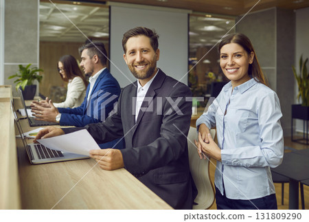 Portrait of happy, smiling business man and woman colleagues at work in the office Portrait of happy, smiling business man and woman colleagues at work in the office 131809290