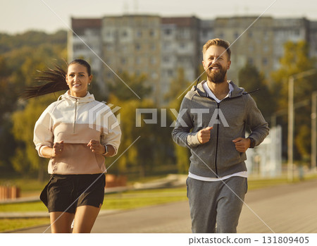 Happy Couple Or Friends Jogging In City Park 131809405