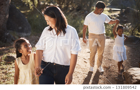 Family, happy and walking in the park for bonding, fun and care in summer outside. Mother, father and parents playfully walk with girl children, kids and siblings in nature garden for summer bonding 131809542