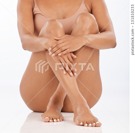 Legs, skincare and spa pedicure of a woman in isolated studio with white background. Beauty, hair removal and epilation of a young model after waxing and body care with leg skin glow on the floor 131810233