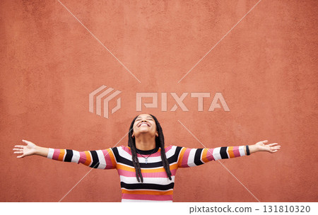 Black woman, open arms and wall background with space for mock up with smile, happiness and excited in city. Young gen z girl, outdoor and happy with mockup, fashion and palm with product placement 131810320