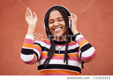 Black woman, music headphones and wall with smile in city for walk, adventure and listening to edm on radio. Young gen z girl, streaming hip hop or techno on website, internet and happiness in metro Black woman, music headphones and wall with smile in city for walk, adventure and listening to edm on radio. Young gen z girl, streaming hip hop or techno on website, internet and happiness in metro 131810323