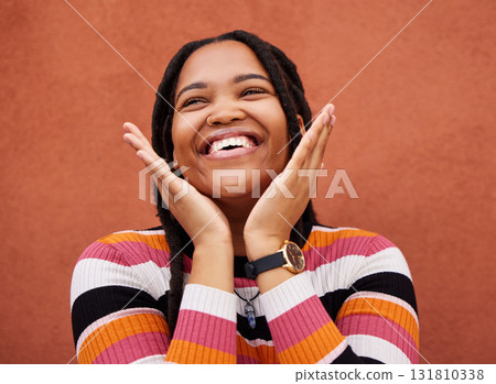 Happy, laugh and freedom with a black woman on an orange background outdoor for joy or humor. Funny, laughter and smile with an african american person laughing or joking against a color wall 131810338