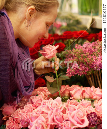 Woman, smelling roses and retail for floral bouquet for scent, color and shopping for valentines day gift. Flowers, leaves and sustainable plants for beauty, present and sale in startup florist store 131810377
