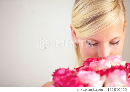 Smelling, floral and woman with flowers as a gift isolated on a grey studio background. Surprise, romantic and girl with a bouquet of roses for valentines day on a backdrop with mockup space 131810423
