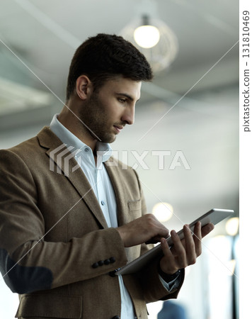 Technology, internet and businessman with tablet reading email, sales or social media on web. Research, leadership and company ceo networking with online communication in management at startup office 131810469