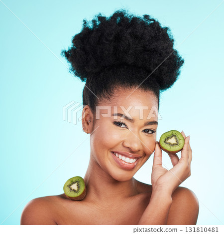 Kiwi fruit, skincare and woman portrait of beauty, wellness and detox healthcare. Isolated, blue background and studio with a young female feeling happy from healthy food with vitamin c for glow 131810481