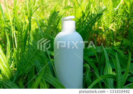 White plastic bottle for cream, balm or oil on the green grass. Nature background for cosmetic. White plastic bottle for cream, balm or oil on the green grass. Nature background for cosmetic. 131810492