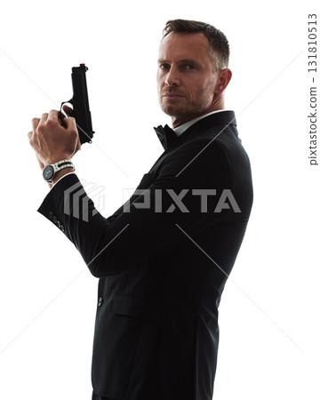 Spy man, portrait and gun with suit for undercover mission, justice or espionage by white background. Government agent, detective and weapon in studio with designer tuxedo, secret information and job 131810513