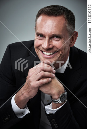 Portrait of mature man, tuxedo and smile, handsome face and serious isolated on grey background in studio. Luxury, glamour and wealth, success and elegant celebrity actor or valentines day date. 131810522