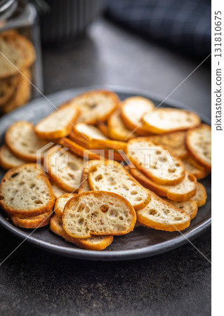 Crispy roasted bruschetta bread on plate on black table. Crispy roasted bruschetta bread on plate on black table. 131810675