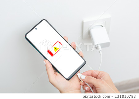 Woman hands plugging a charger in a smartphone, close up. Low battery level, charging modern device with USB Type-C 131810788