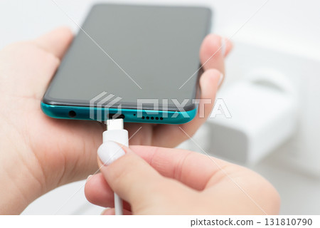 Inserting usb type-c into smartphone, close up. Modern fast charging of the device, universal usb port 131810790