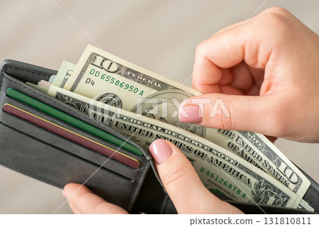 Dollar money in grey wallet, female hands holding them. Ten dollar banknotes and credit cards, close up 131810811