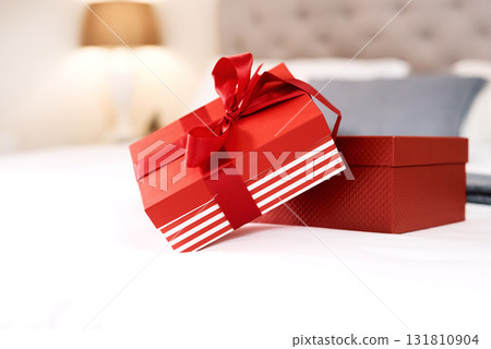 Present, love gift and bedroom with no people with celebration box for valentines day. Red gifts, presents and bed in a house with surprise, celebrating and birthday package with ribbon and zoom Present, love gift and bedroom with no people with celebration box for valentines day. Red gifts, presents and bed in a house with surprise, celebrating and birthday package with ribbon and zoom 131810904