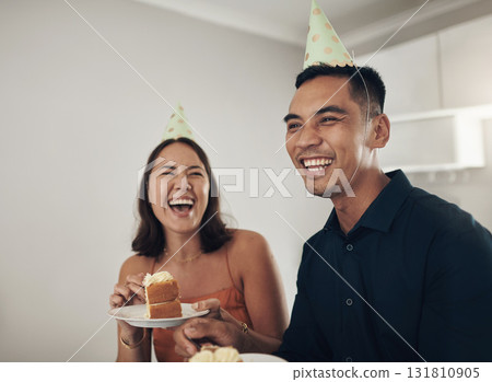 Love, couple eating cake and birthday party with smile, loving and celebration for achievement and joyful. Romantic, man and woman with hats, dessert and laughing together in living room and cheerful Love, couple eating cake and birthday party with smile, loving and celebration for achievement and joyful. Romantic, man and woman with hats, dessert and laughing together in living room and cheerful 131810905