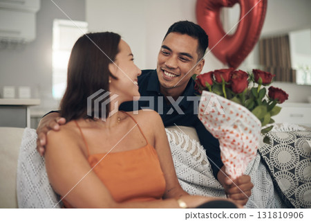 Valentines day, flowers and couple on a living room sofa with a present and a smile. Happy, love and care of young people together with celebration rose on a date in a house on a couch with a gift Valentines day, flowers and couple on a living room sofa with a present and a smile. Happy, love and care of young people together with celebration rose on a date in a house on a couch with a gift 131810906