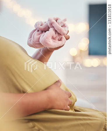 Baby shoes, pregnant stomach and woman hands with baby clothes holding her abdomen. Mother, mom love and gratitude of a new mama with family care for pregnancy in a living room lounge with slippers Baby shoes, pregnant stomach and woman hands with baby clothes holding her abdomen. Mother, mom love and gratitude of a new mama with family care for pregnancy in a living room lounge with slippers 131811018