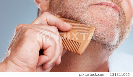 Grooming, hair care and man brush beard for wellness, healthy skin and hygiene on blue background. Salon aesthetic, cleaning and face zoom of male with barber comb for facial, skincare and beauty Grooming, hair care and man brush beard for wellness, healthy skin and hygiene on blue background. Salon aesthetic, cleaning and face zoom of male with barber comb for facial, skincare and beauty 131811065