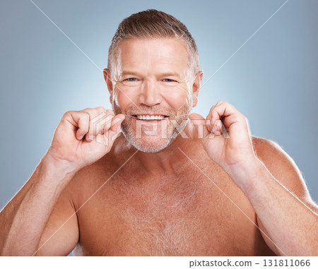 Floss, portrait and man with oral hygiene to clean mouth, wellness and guy against blue studio background. Male, gentleman and string for fresh breath, dental health and morning routine or grooming Floss, portrait and man with oral hygiene to clean mouth, wellness and guy against blue studio background. Male, gentleman and string for fresh breath, dental health and morning routine or grooming 131811066