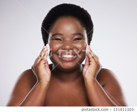 Black woman, skincare and studio portrait with cotton pad for cleaning, skin glow or wellness with smile. African model, cosmetics and makeup for dermatology, aesthetic or facial health for self care 131811103