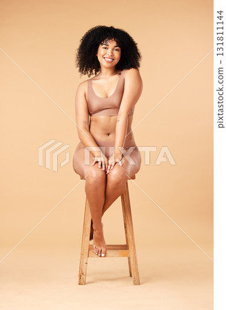 Body positive, beauty and black woman sitting on a chair for skincare and self care isolated in a studio brown background. Plus size, portrait and natural model smile, happy and glow due to cosmetic Body positive, beauty and black woman sitting on a chair for skincare and self care isolated in a studio brown background. Plus size, portrait and natural model smile, happy and glow due to cosmetic 131811144
