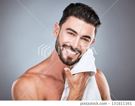 Skincare, wellness and portrait of a happy man in a studio with a self care, natural and face routine. Health, dermatology and male model with a facial towel for treatment isolated by gray background Skincare, wellness and portrait of a happy man in a studio with a self care, natural and face routine. Health, dermatology and male model with a facial towel for treatment isolated by gray background 131811161