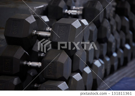 Fitness, workout and dumbbells in empty gym for exercise, bodybuilding development and sports training club. Background zoom of heavy steel weights, equipment and iron for lifting in wellness studio Fitness, workout and dumbbells in empty gym for exercise, bodybuilding development and sports training club. Background zoom of heavy steel weights, equipment and iron for lifting in wellness studio 131811361