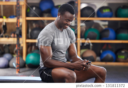 Phone, fitness and black man in gym training, workout or exercise social media or internet search for health tips. Bodybuilder, sports person listening to music or typing on smartphone chat or mobile Phone, fitness and black man in gym training, workout or exercise social media or internet search for health tips. Bodybuilder, sports person listening to music or typing on smartphone chat or mobile 131811372