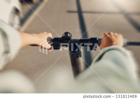 Electric scooter, travel and person hands driving on urban street for eco friendly journey to university. Carbon footprint, speed or fast moving student on energy saving transport for college in POV 131811409